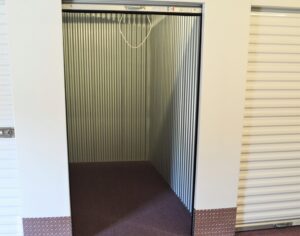 empty climate controlled storage unit interior at AA Self Storage in Lynchburg VA showing metal corrugated walls and roll-up door