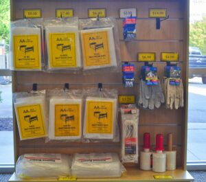 packing supplies display at AA Self Storage in Lynchburg VA including mattress bags, bubble wrap, tape, and work gloves with pricing