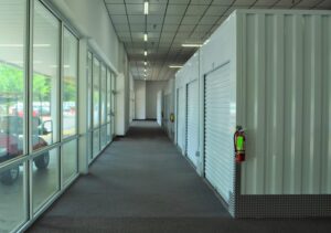brightly lit indoor hallway at the Raleigh NC self storage facility featuring climate controlled units and large windows