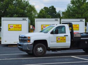 AA Self Storage white flatbed truck and portable storage containers at the Raleigh NC facility on Tryon Road