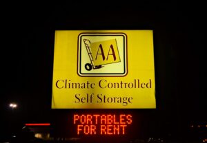 illuminated roadside sign at night in Raleigh NC advertising climate controlled self storage and portable rentals